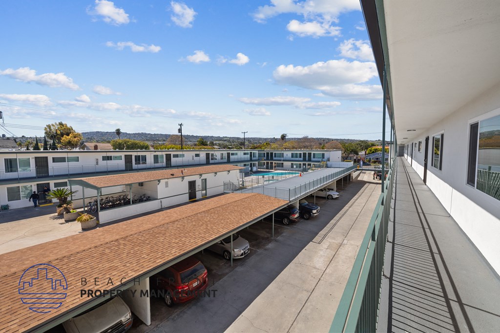 A parking lot with a few cars and a building in the background.