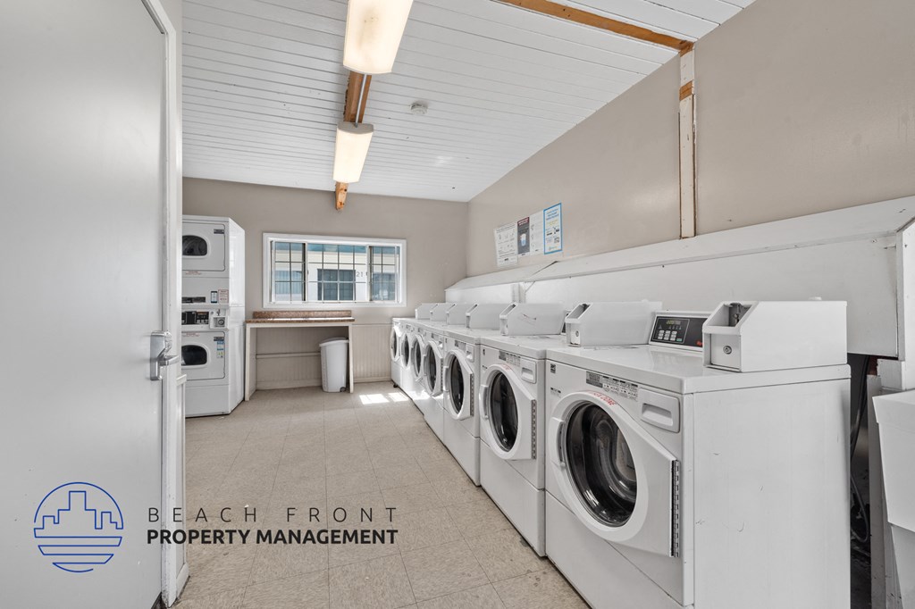 A laundry room with washers and dryers and a logo for Beach Front Property Management.