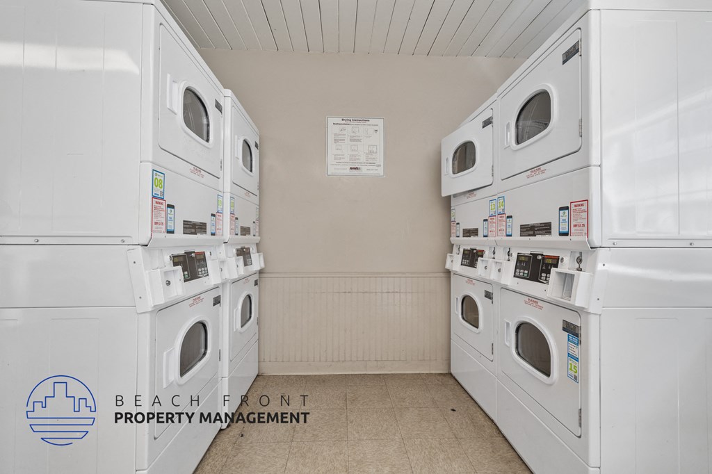 A laundry room with washers and dryers and a sign that says Beach Front Property Management.