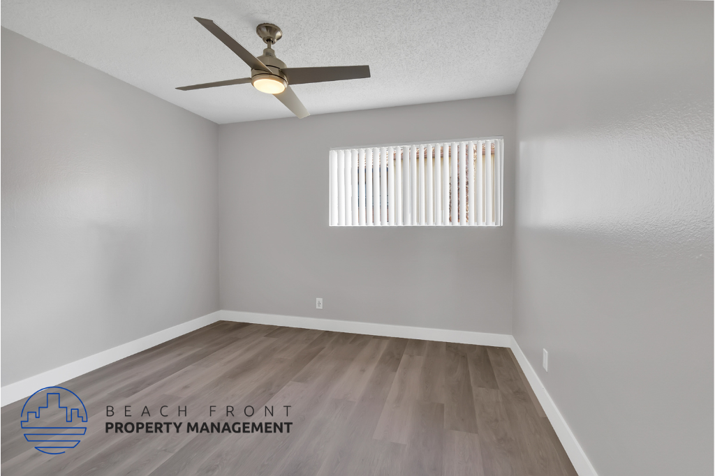the spacious living room has a ceiling fan and a window