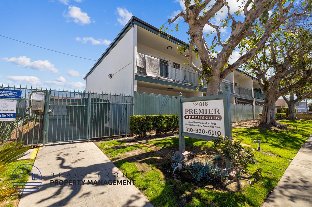 A white building with a sign that says Premier in front of it.