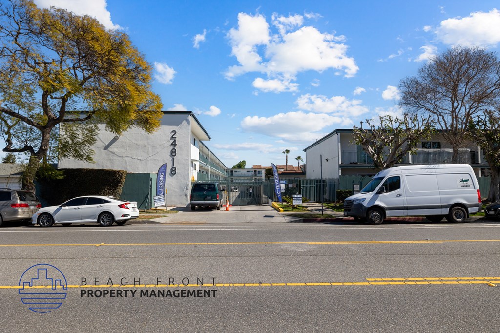 A white van is parked in front of a building with the sign "BEACH FRONT PROPERTY MANAGEMENT".