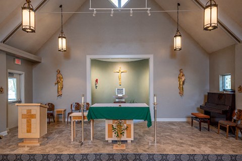 the sanctuary of a church with a cross and a green table