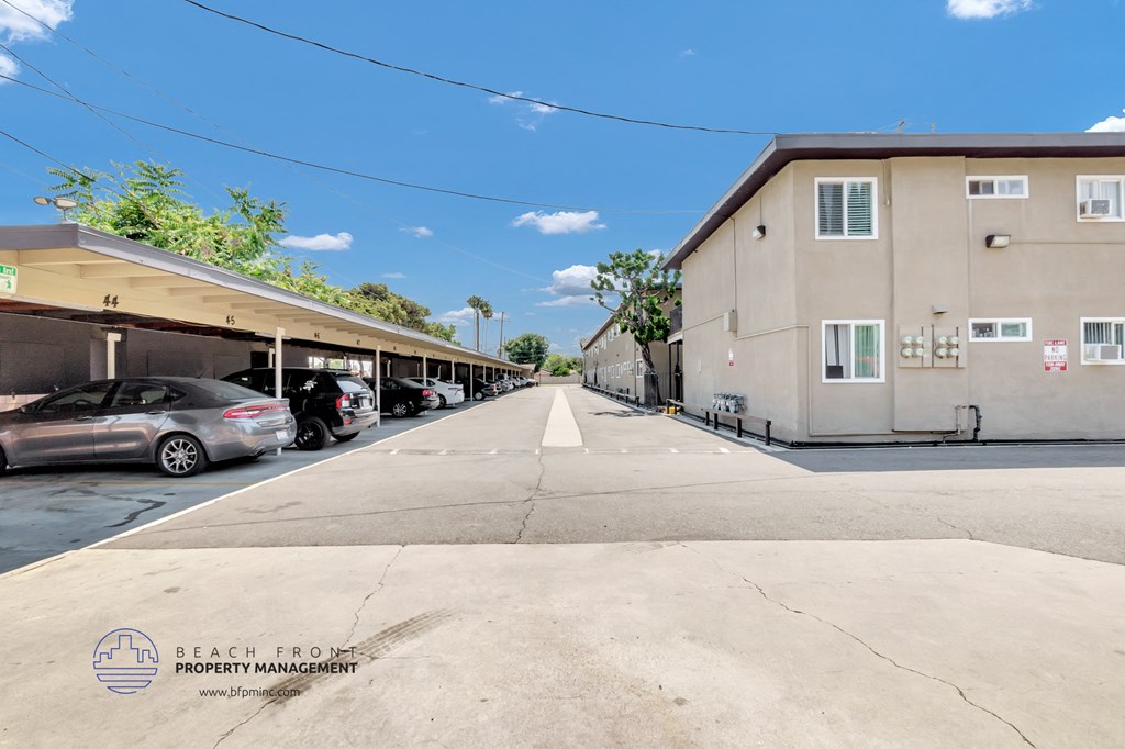 a parking lot in front of a building with a blue sky in the background