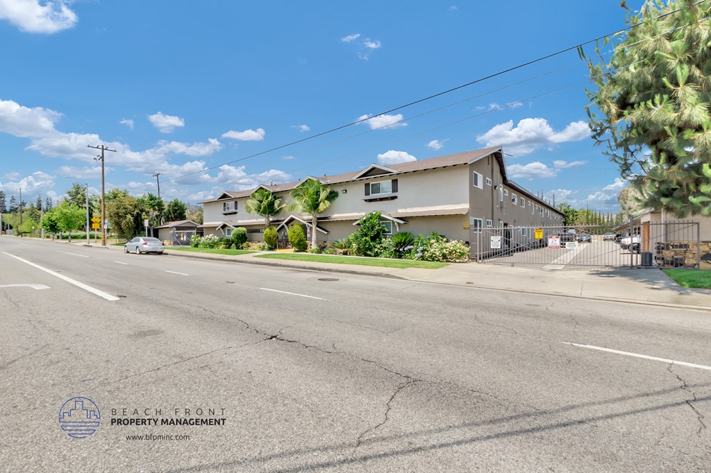 a view from the street of a row of houses on a sunny day with a blue sky