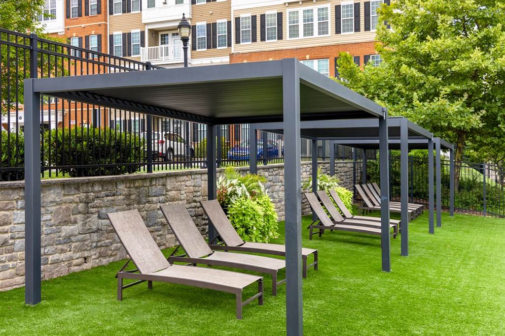 a group of lounge chairs under a canopy on a lawn