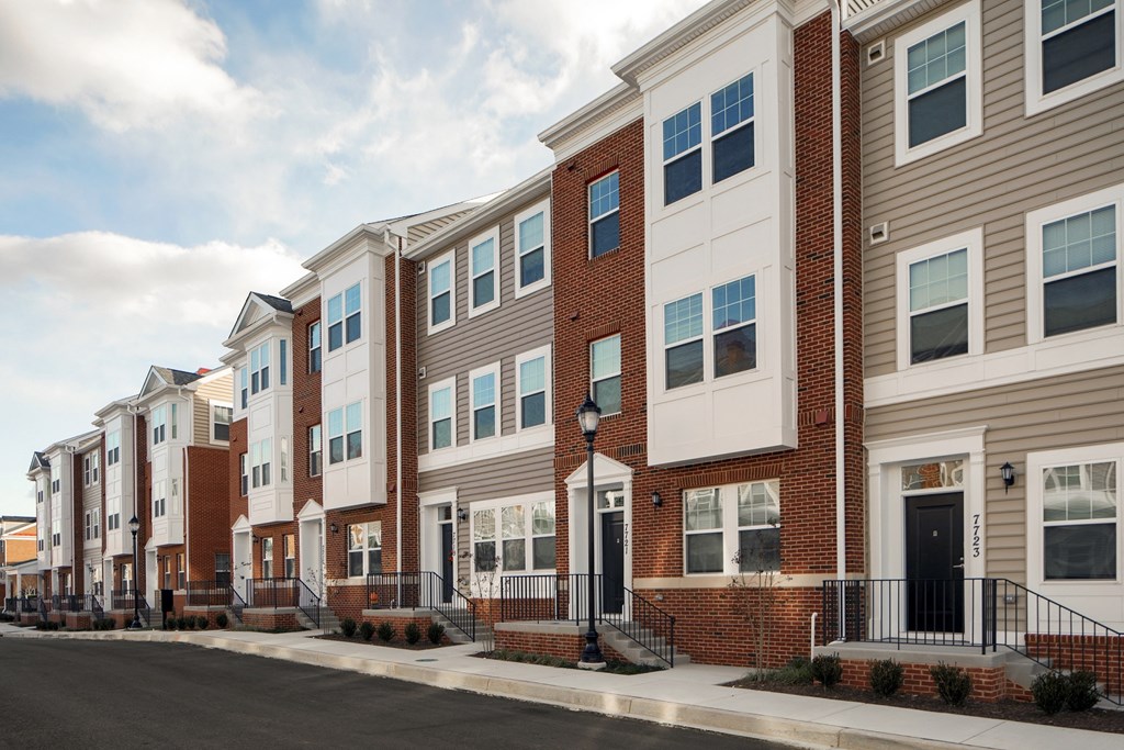 a row of brick and white town houses on a street