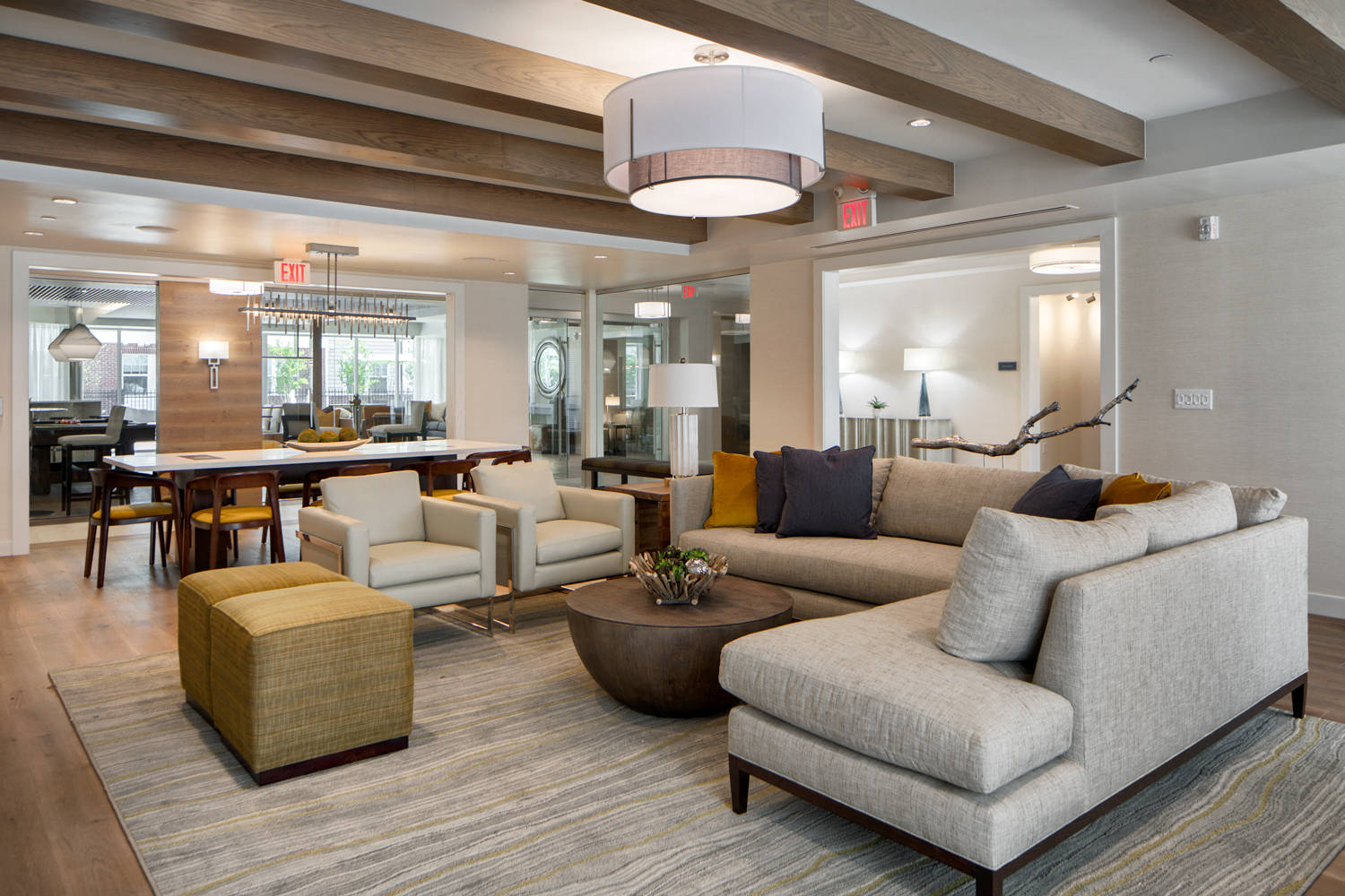 Community living room with plenty of comfortable seating, bar area for socializing, kitchen amenities, billiards table, and business area with available computers