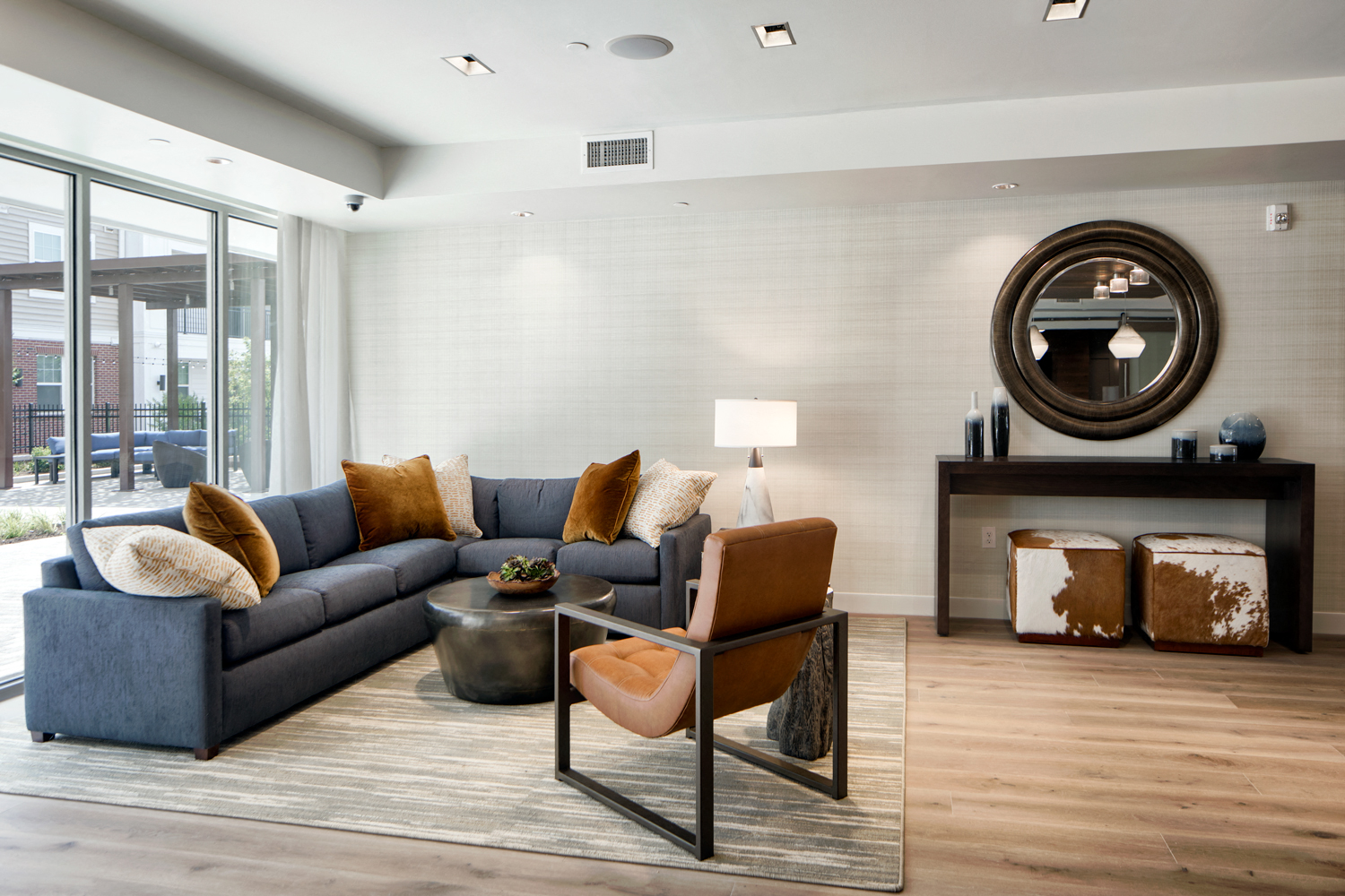 Community living room with plenty of comfortable seating, bar area for socializing, kitchen amenities, billiards table, and business area with available computers