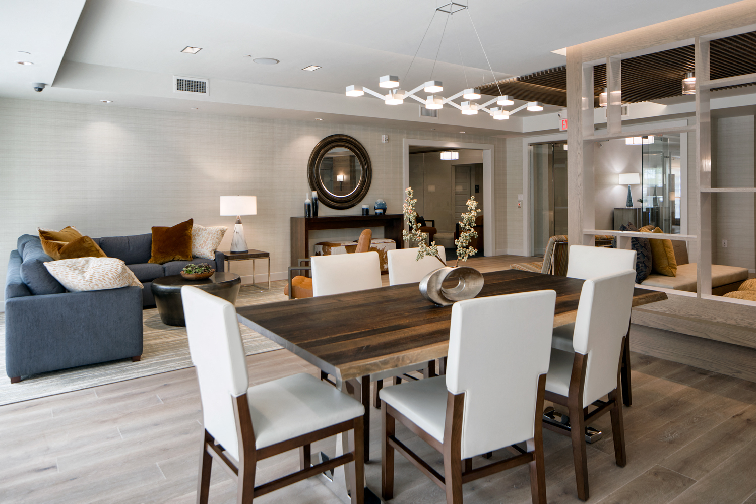 Community living room with plenty of comfortable seating, bar area for socializing, kitchen amenities, billiards table, and business area with available computers