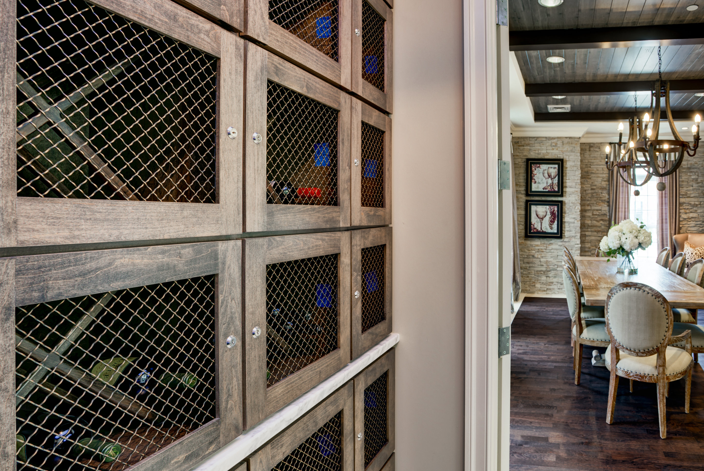 a wine cellar in a dining room with a table and chairs