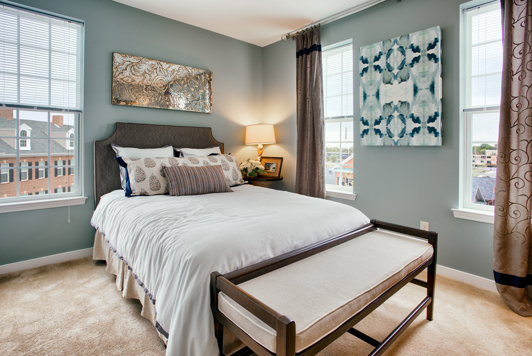 a bedroom with a bed and three windows