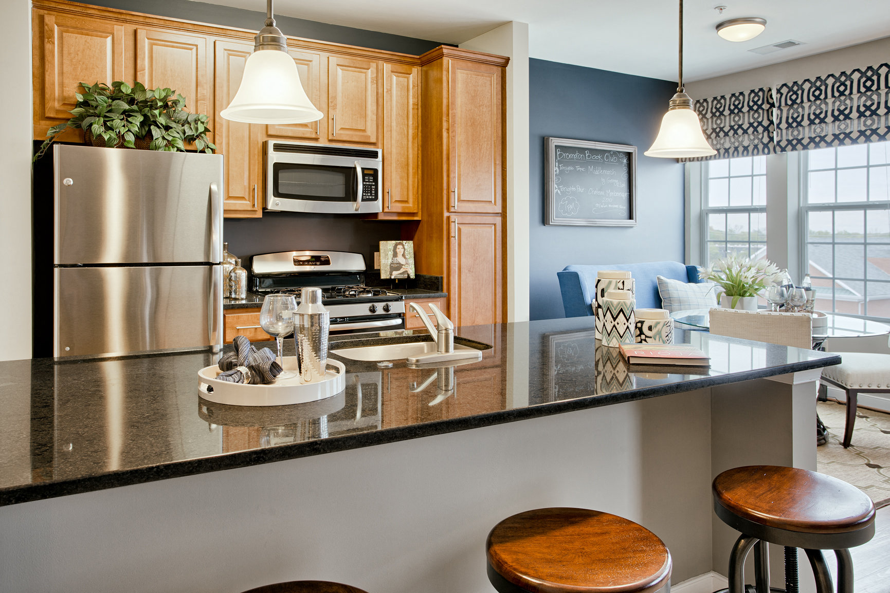 a kitchen with stainless steel appliances and a counter with stools