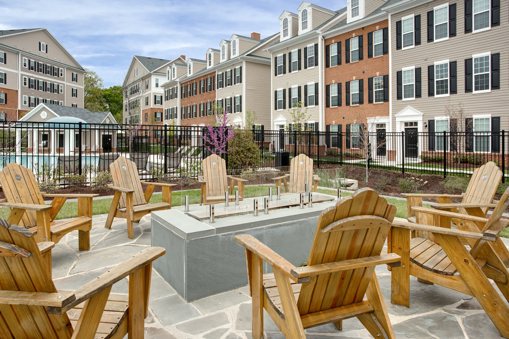 our apartments have a large patio with wooden chairs and tables