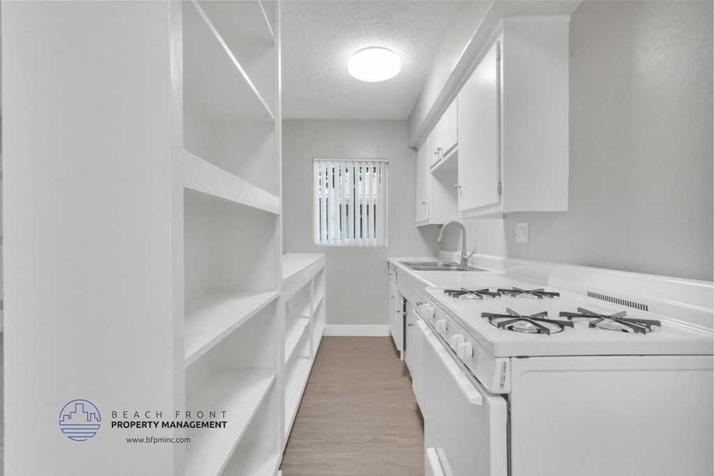an updated kitchen with white appliances and white cabinets and a white stove top oven