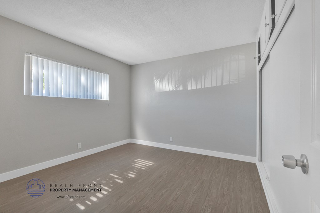 the interior of an empty room with wood flooring and white walls