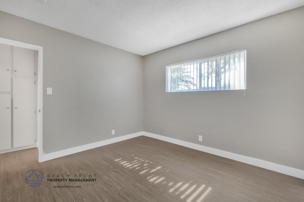 the living room of an empty house with wooden floors and a window