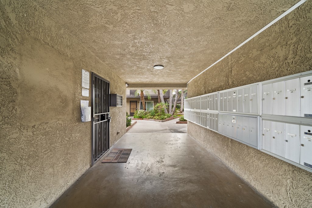a long hallway with rows of lockers and a door