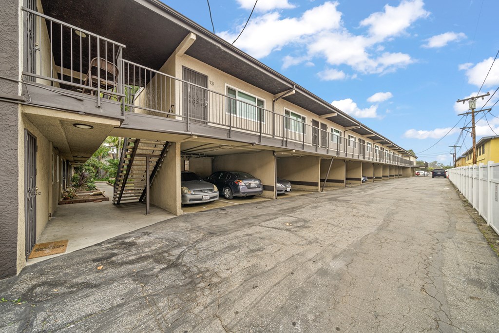 a building with balconies and cars parked underneath it