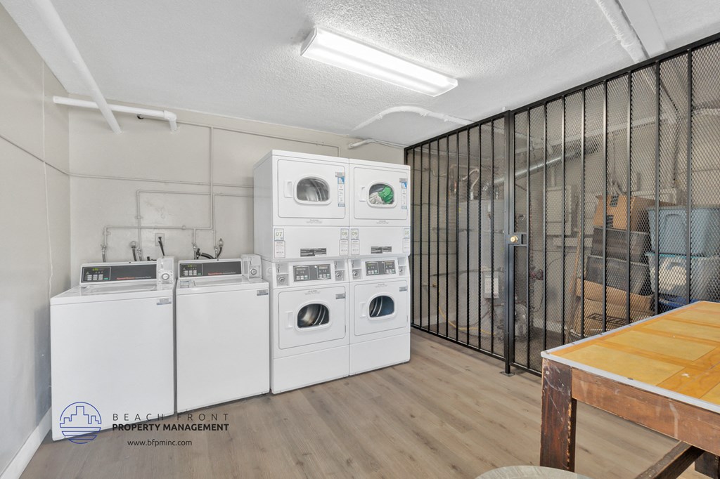 a laundry room with washers and dryers and a table with laundry machines