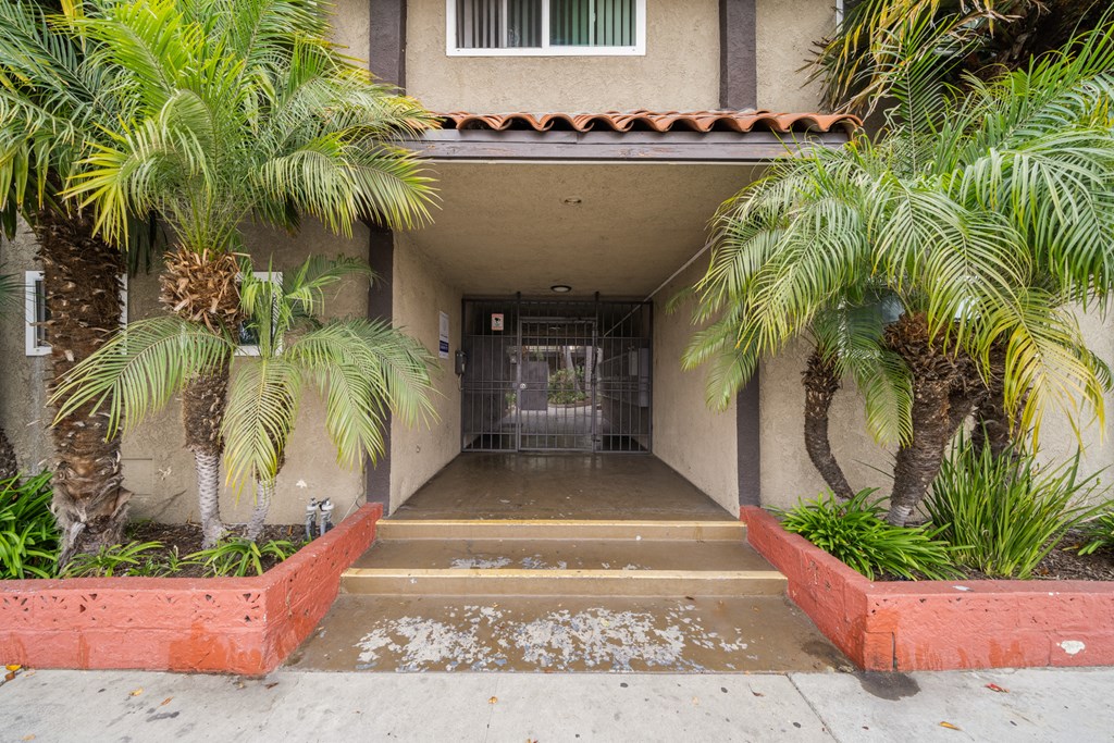the entrance to a building with palm trees