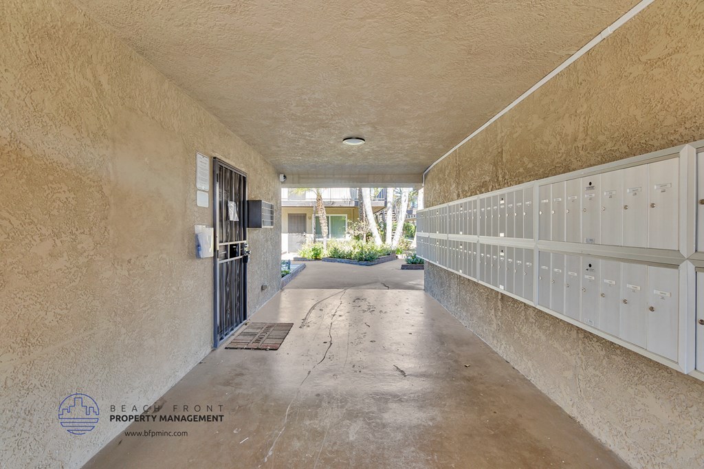 a hallway with white lockers and a door to a building