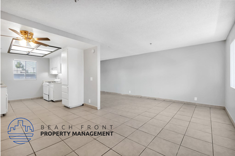 A spacious room with a ceiling fan and tiled floor.
