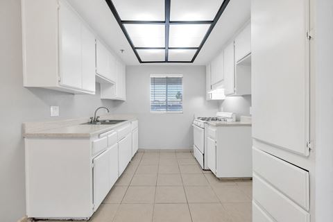 a kitchen with white cabinetry and white appliances