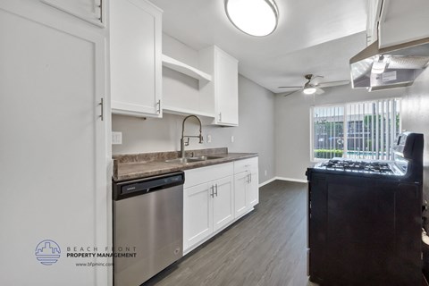 a kitchen with white cabinets and stainless steel appliances and a window