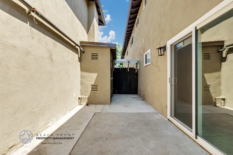 a long walkway between two buildings with a large glass door