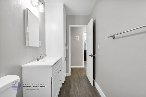 a bathroom with a sink and a mirror and a door to a hallway