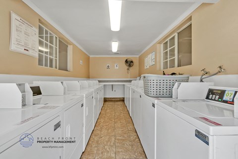 a washer and dryer room filled with white laundry machines