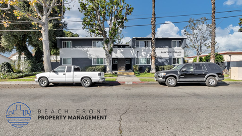 a view of the beach front property management building with two cars parked in front