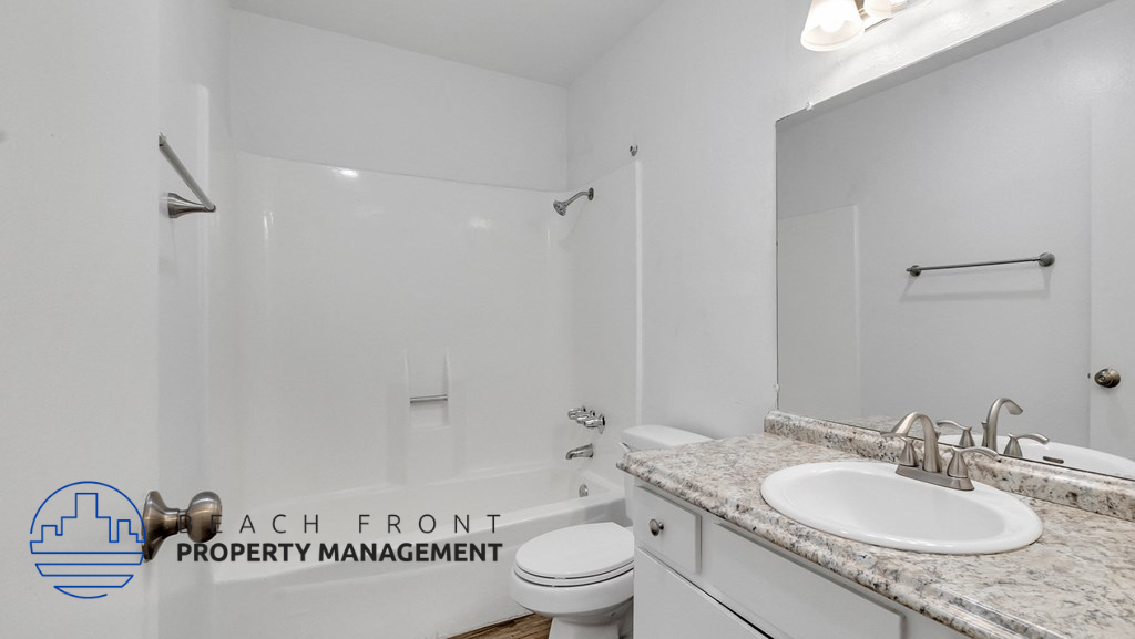 a white bathroom with a sink and a toilet and a shower