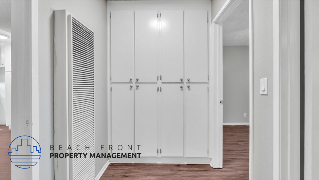 an image of a hallway with white closets and a wood floor