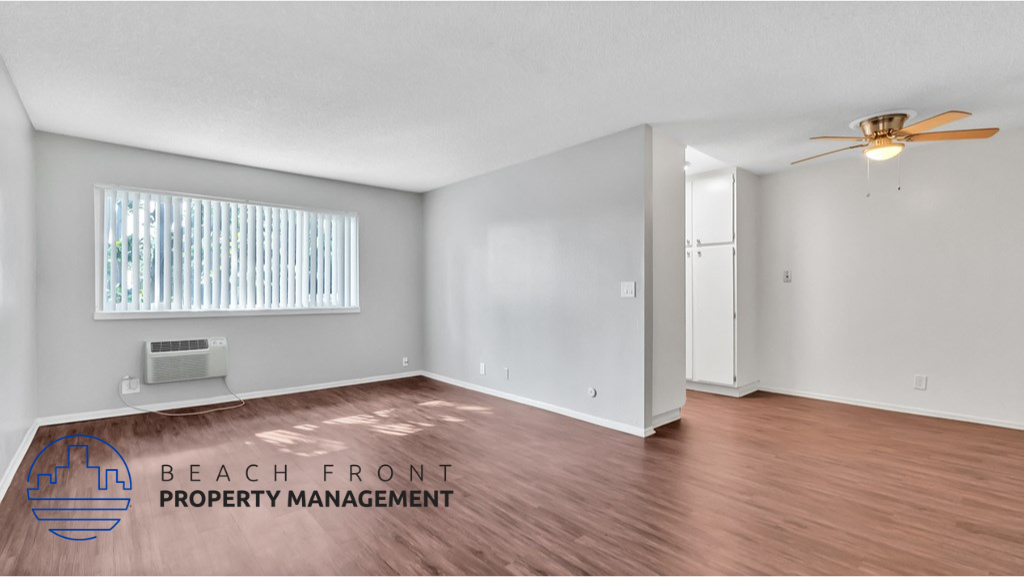 the living room and dining room with wood flooring and a ceiling fan