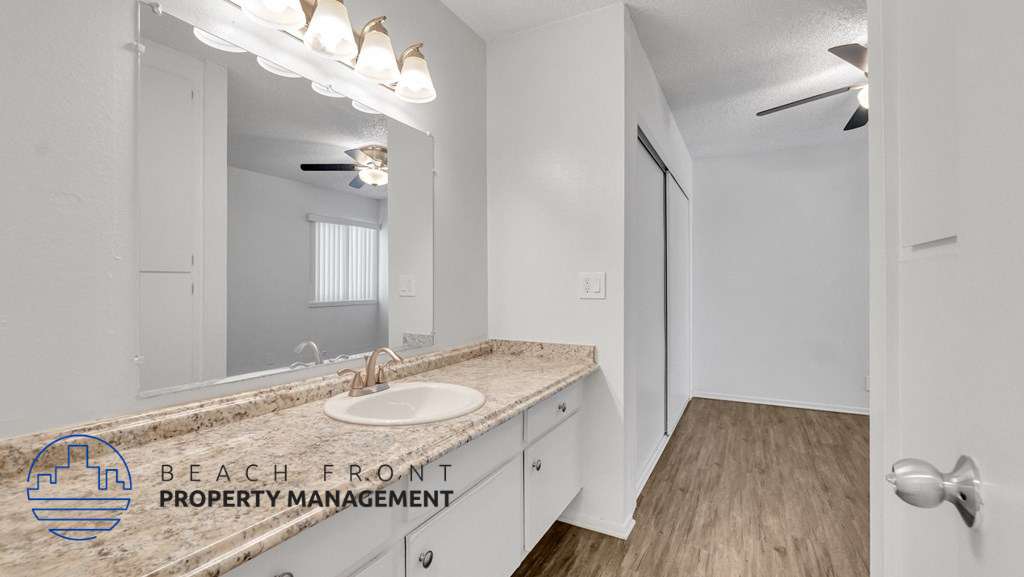 a bathroom with a sink and a mirror and a closet