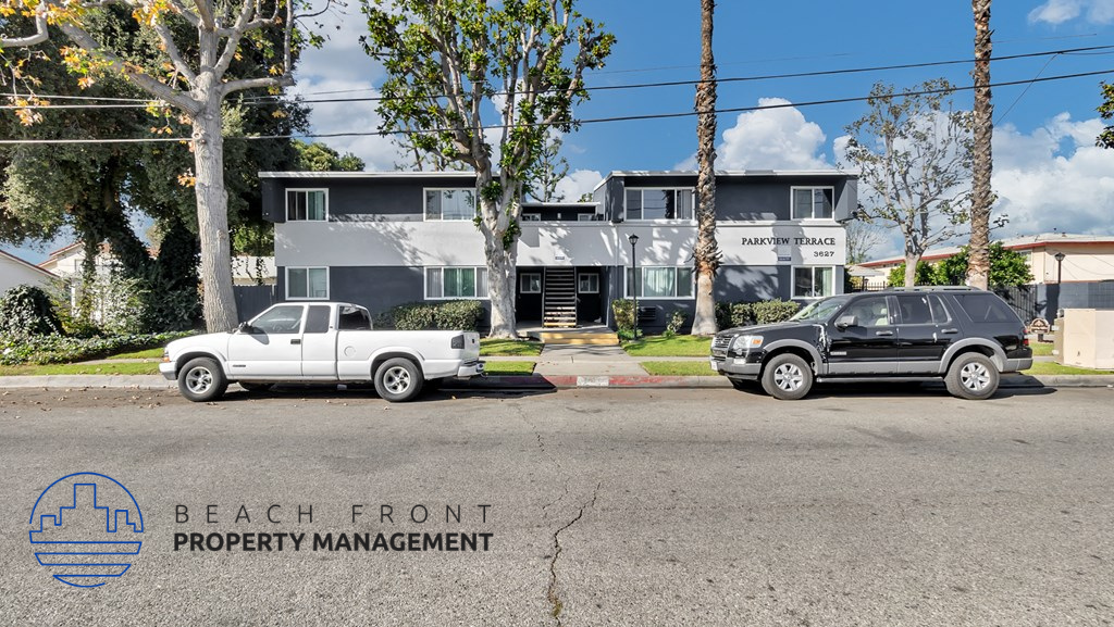 a view of the beach front property management building with two cars parked in front