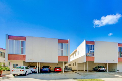 A modern building with cars parked in front.