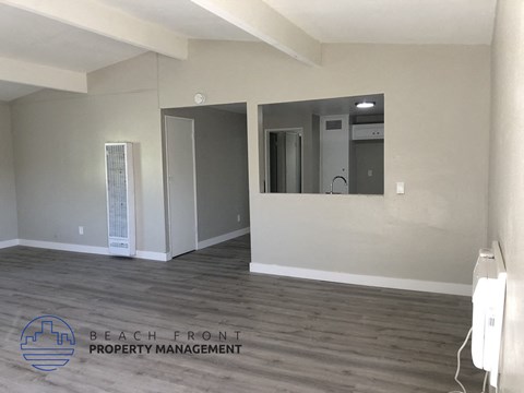 A room with a mirror and a door leading to another room.
