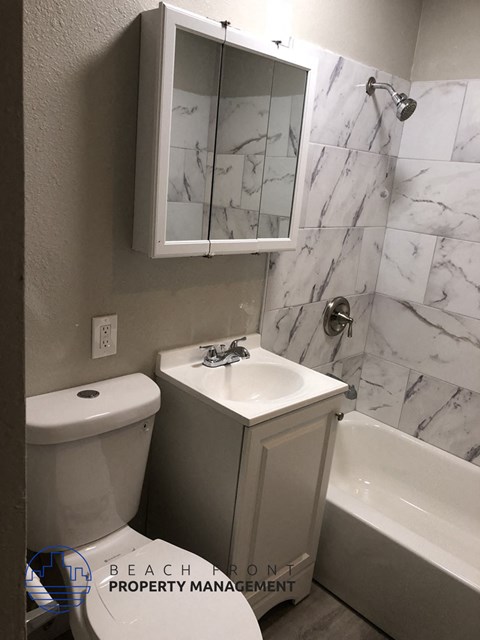 A white toilet and sink in a bathroom.