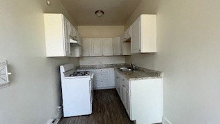 a small kitchen with white cabinets and a stove
