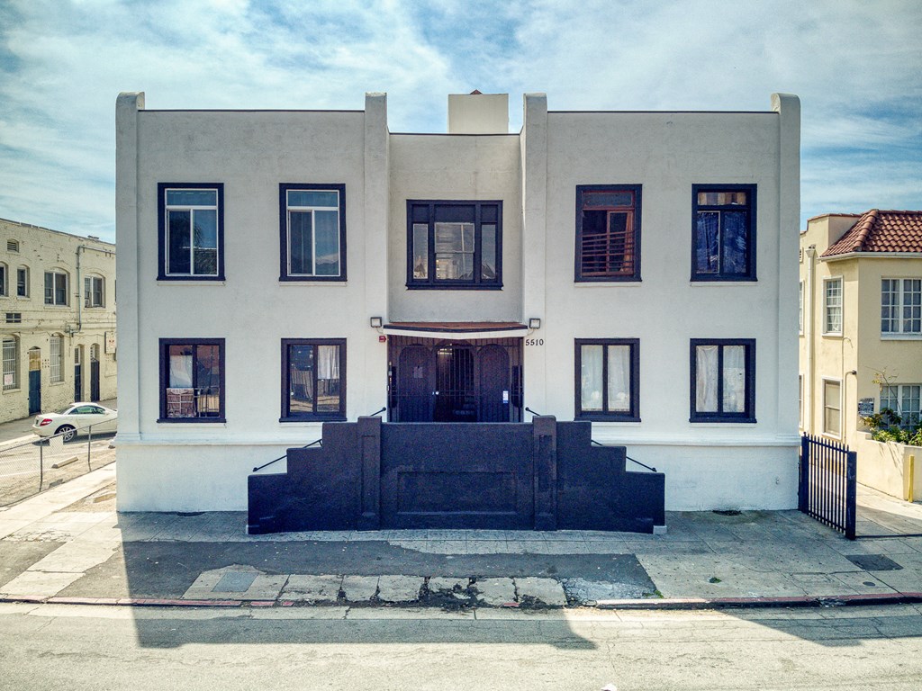 the front of a white house on a city street