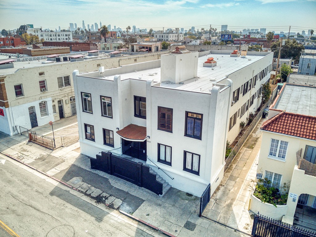 an aerial view of a white building with a city in the background