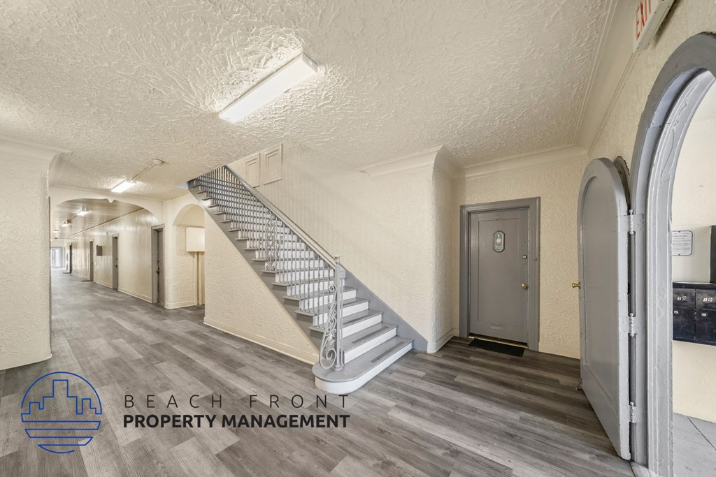 a hallway with a staircase and a door in a building