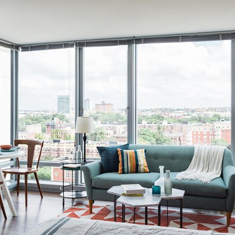 a living room with a green couch and a city view