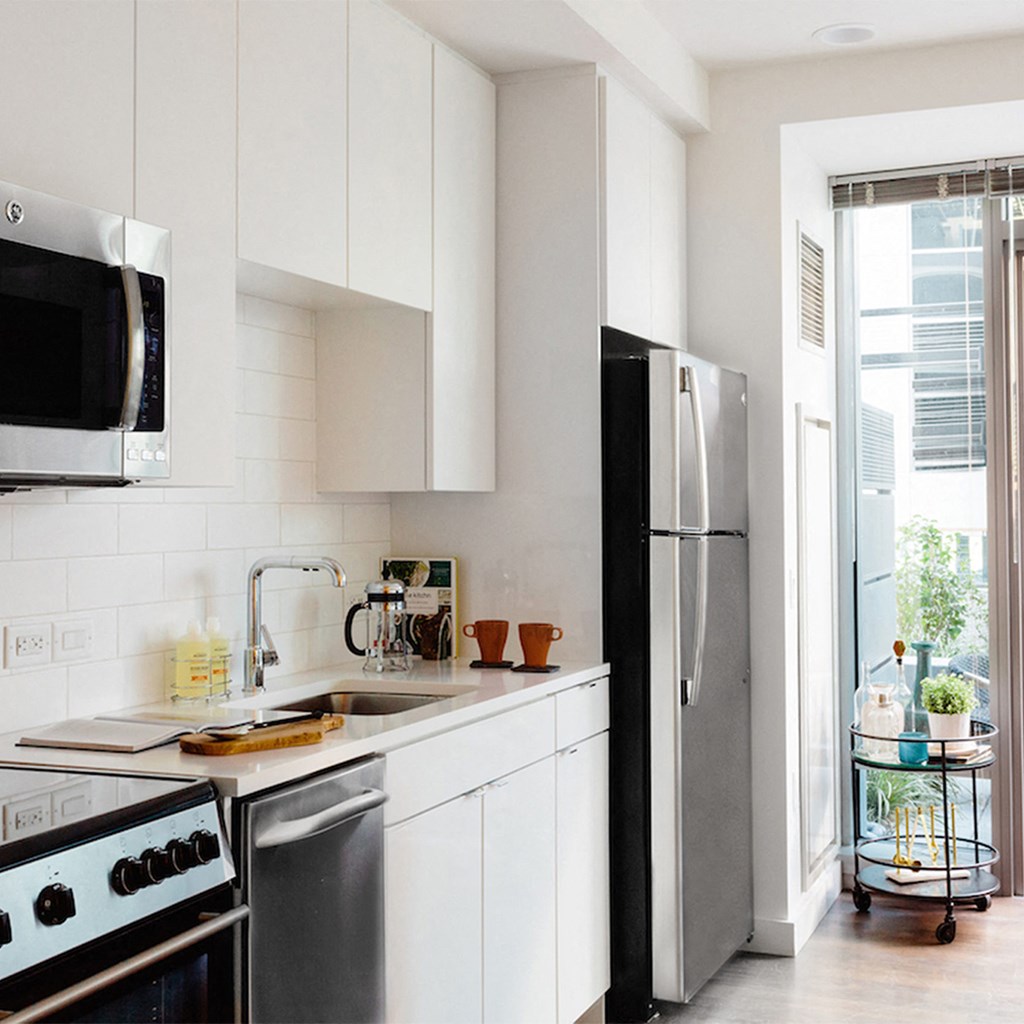 a kitchen with white cabinets and a stainless steel refrigerator