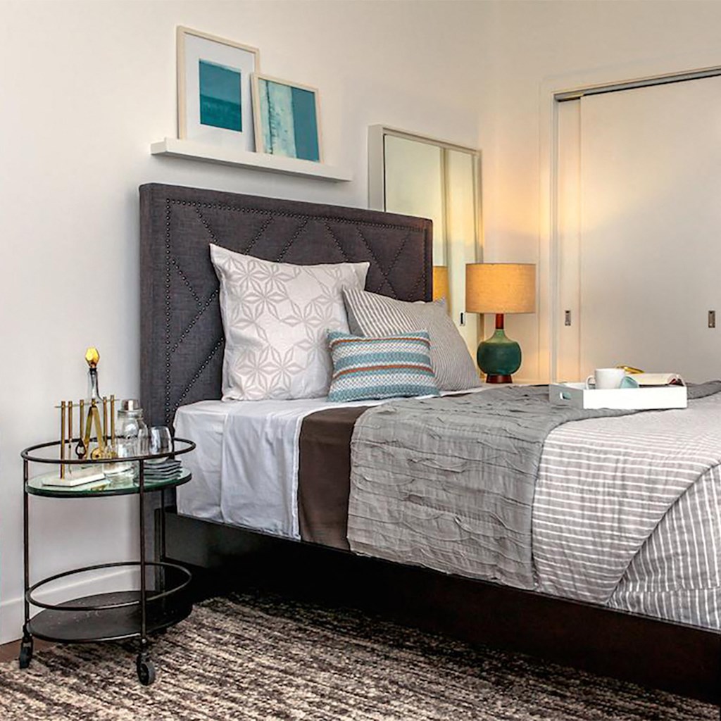 a bedroom with a bed and pillows and a table
