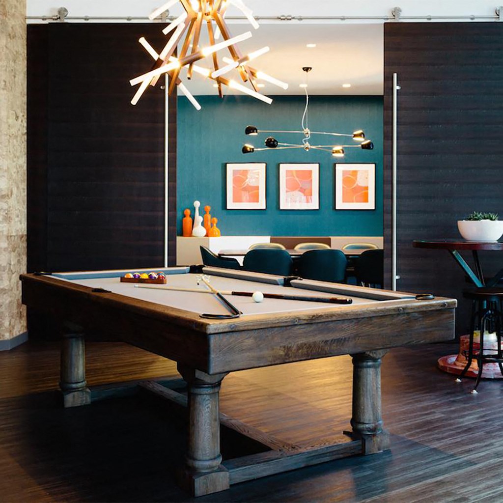 a pool table in a living room with a chandelier