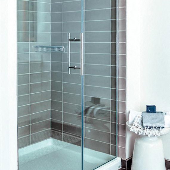 a bathroom with a shower with a glass door